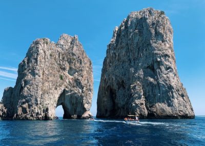 white-boat-passing-stone-formations-on-ocean-3009067